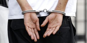 A handcuffed suspect is escorted by police as he arrives at the Paris courts