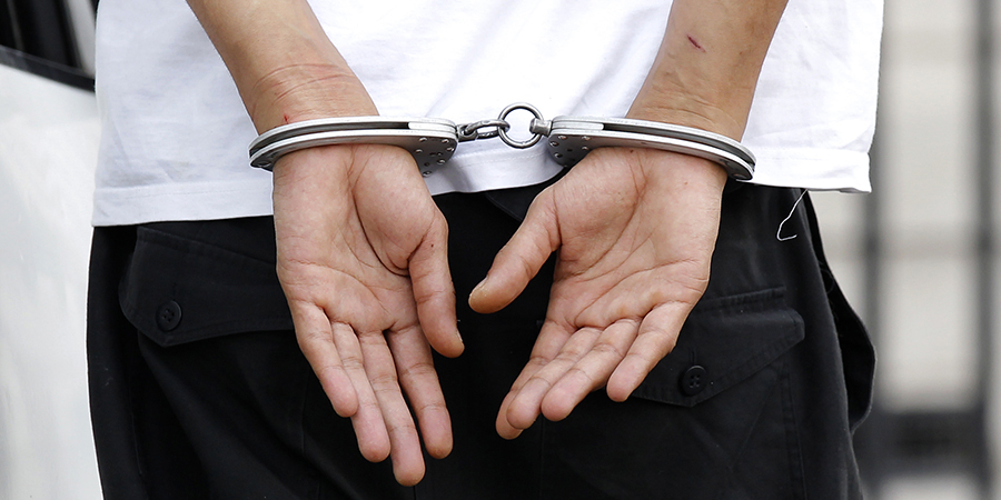 A handcuffed suspect is escorted by police as he arrives at the Paris courts